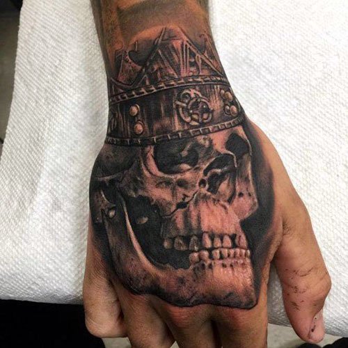 Skull on hand tattoo covering face 